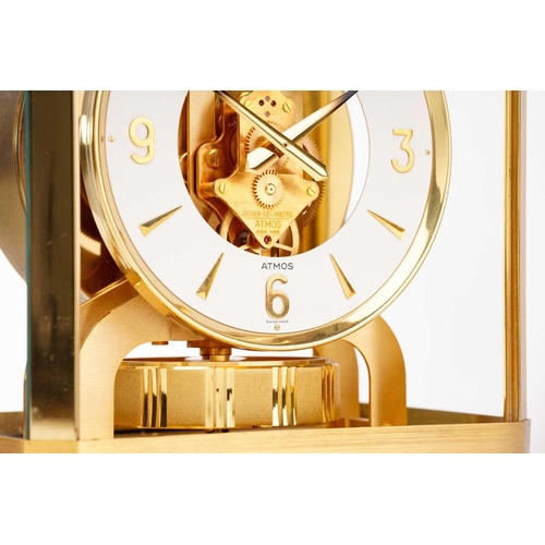 300 - A Jaeger LeCoultre brushed brass Atmos clock, no. 453672, with Arabic numerals at the quarter chapte... 