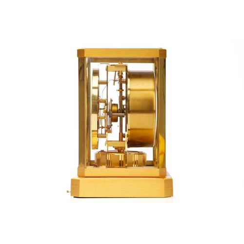 300 - A Jaeger LeCoultre brushed brass Atmos clock, no. 453672, with Arabic numerals at the quarter chapte... 