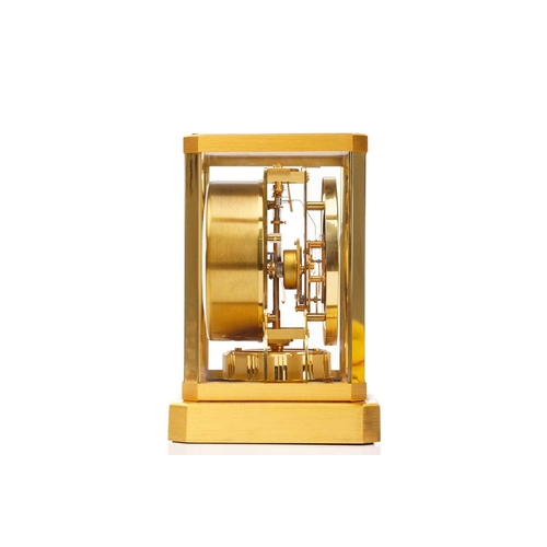 300 - A Jaeger LeCoultre brushed brass Atmos clock, no. 453672, with Arabic numerals at the quarter chapte... 