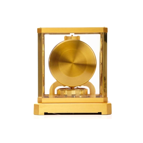 300 - A Jaeger LeCoultre brushed brass Atmos clock, no. 453672, with Arabic numerals at the quarter chapte... 