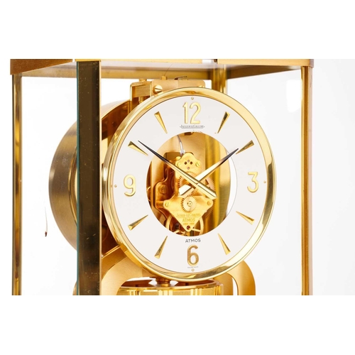 300 - A Jaeger LeCoultre brushed brass Atmos clock, no. 453672, with Arabic numerals at the quarter chapte... 