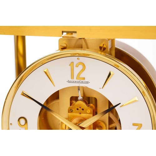 300 - A Jaeger LeCoultre brushed brass Atmos clock, no. 453672, with Arabic numerals at the quarter chapte... 