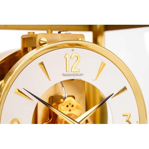 300 - A Jaeger LeCoultre brushed brass Atmos clock, no. 453672, with Arabic numerals at the quarter chapte... 