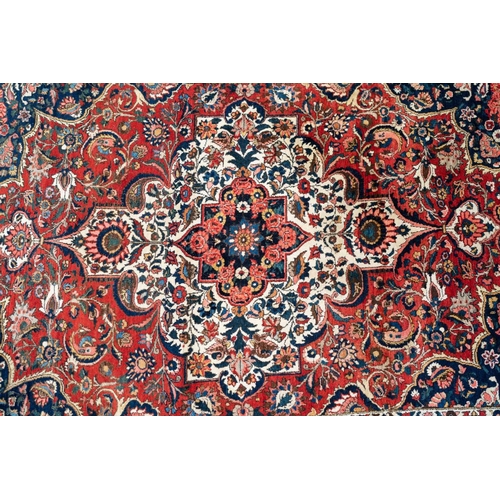 302 - A red ground Bidjar carpet with book cover design within broad palmette borders, 260 cm x 169 cm