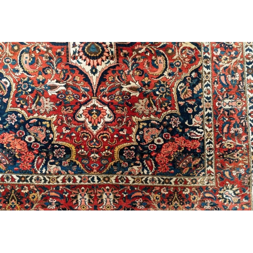 302 - A red ground Bidjar carpet with book cover design within broad palmette borders, 260 cm x 169 cm