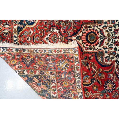 302 - A red ground Bidjar carpet with book cover design within broad palmette borders, 260 cm x 169 cm