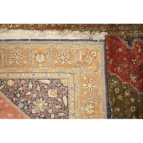 304 - An old brick red ground silk on silk Tabriz rug with central geometric lozenge with hanging lanterns... 