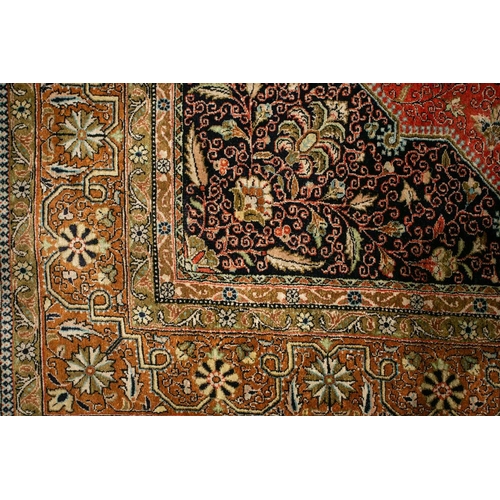 304 - An old brick red ground silk on silk Tabriz rug with central geometric lozenge with hanging lanterns... 