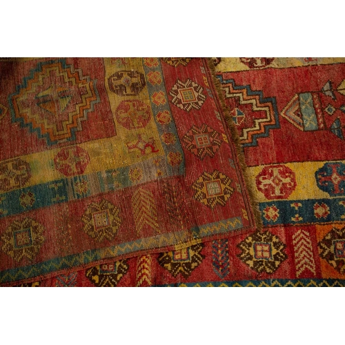 312 - A lacquer red ground probably Luri Gabbeh runner with four stepped diamond design within geometric b... 