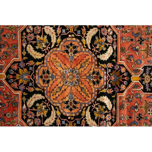 313 - An old brick red ground Heriz style silk on silk rug with central star lozenge with hanging lanterns... 