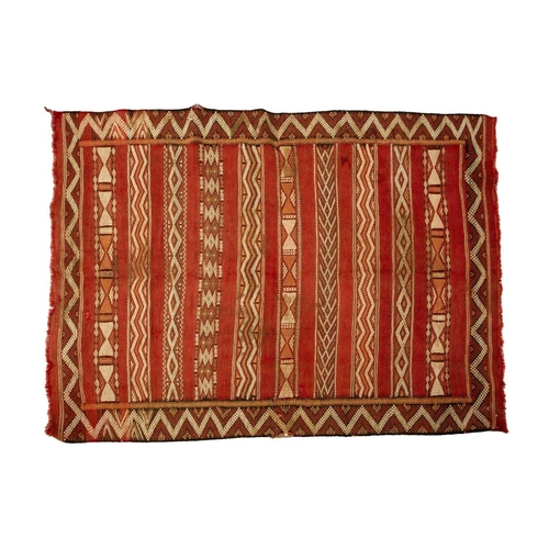 318 - A North African red ground kelim with banded decoration. within a zig-zag border, 1.6 mtrs x 1,1 mtr... 