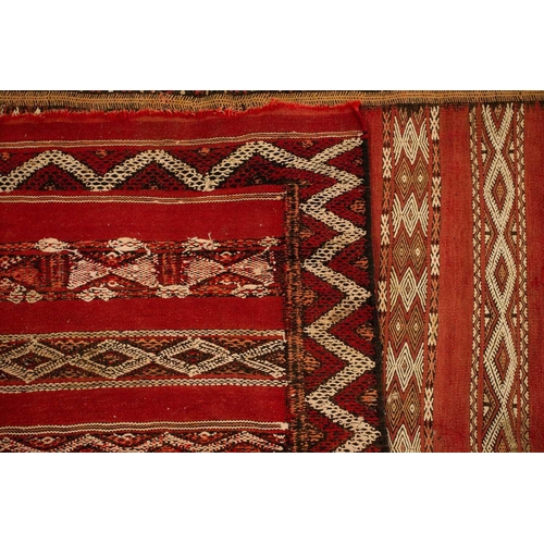 318 - A North African red ground kelim with banded decoration. within a zig-zag border, 1.6 mtrs x 1,1 mtr... 