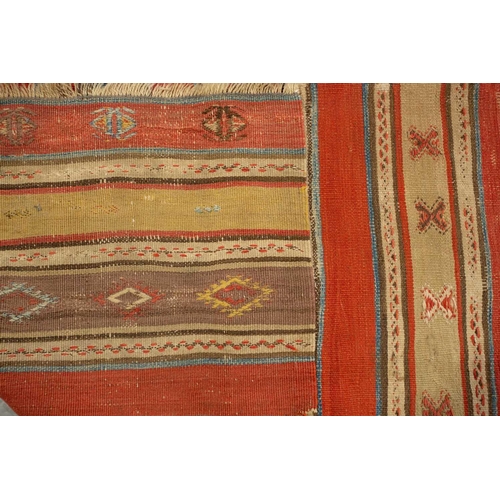 318 - A North African red ground kelim with banded decoration. within a zig-zag border, 1.6 mtrs x 1,1 mtr... 