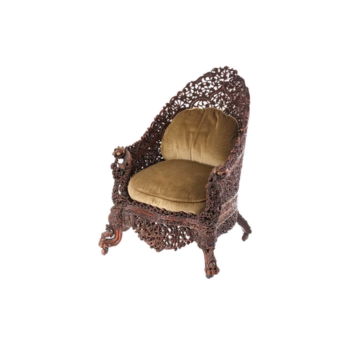 332 - A 19th century Anglo Indian carved and pierced paduak wood high back tub chair, the arched back prof... 