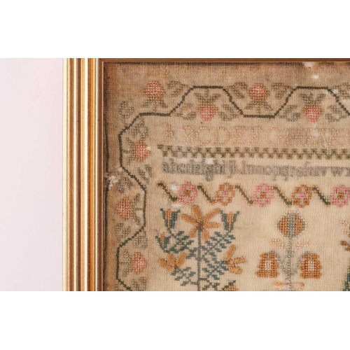 356 - A George III woolwork sampler, with the alphabet over a house surrounded by trees and pots of plants... 