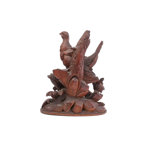 357 - A pair of Black Forest carved wood figures of partridges, with their offspring, on ivy-carved natura... 