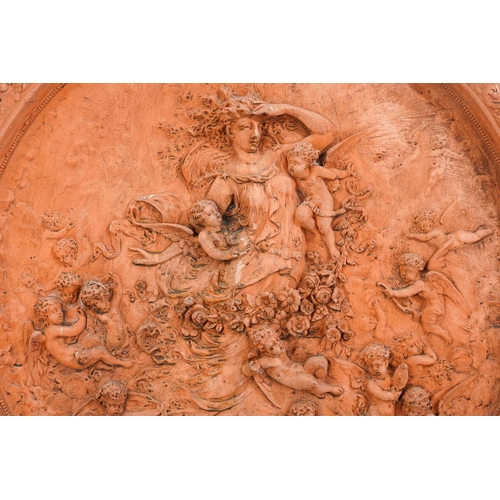 428 - A large terracotta relief garden plaque, depicting a Goddess surrounded by cherubs, within a floral ... 