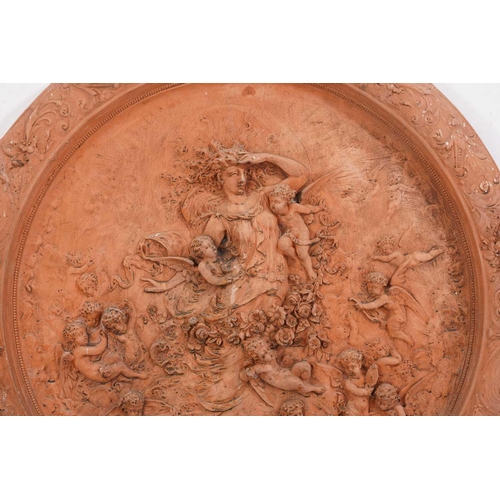 428 - A large terracotta relief garden plaque, depicting a Goddess surrounded by cherubs, within a floral ... 