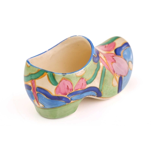 444 - A Clarice Cliff Fantasque design clog in a blue floral design, (with chip), 11 cm long, and a Claric... 