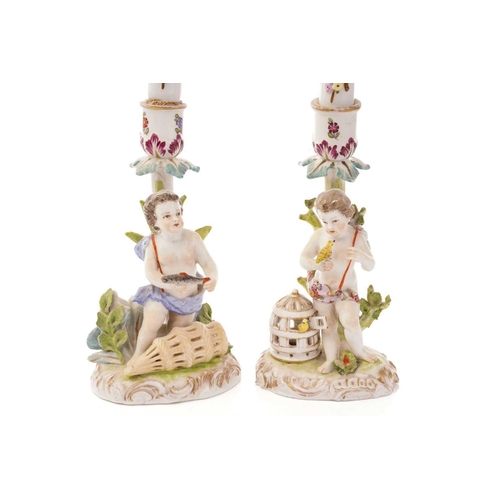 446 - A pair of Dresden porcelain candlesticks, with flower encrusted porcelain candles, each depicting pu... 