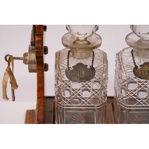 464 - An Edwardian oak and silver-plated three-bottle tantalus with silverplated fittings with a locking b... 