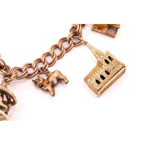 113 - A 9ct gold charm bracelet with nine assorted charms, consisting of a double curb link chain, suspend... 