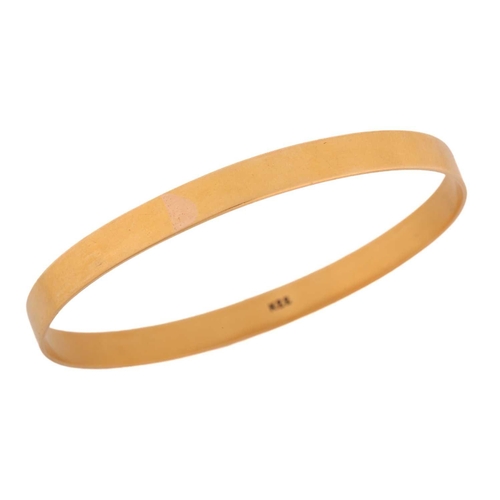 117 - A yellow metal closed bangle, with a solid flat band, marked as 'K22', internal circumference approx... 