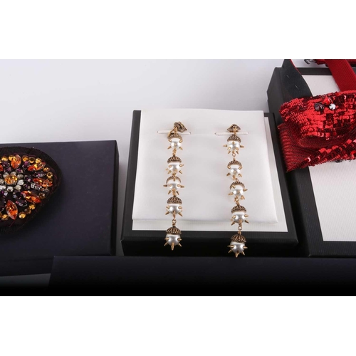 145 - A collection of branded fashion accessories; to include three Prada beaded brooches, and a rhineston... 