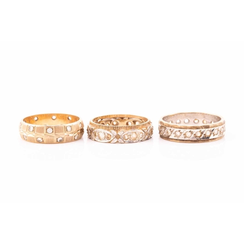 151 - A collection of seven rings, comprising of a three-stone ring set into yellow metals stamped 18ct, a... 