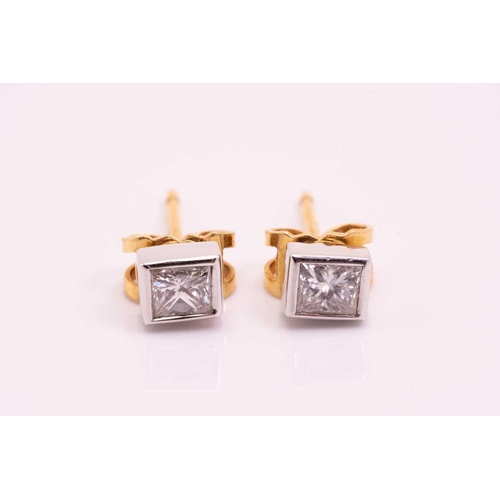 16 - A pair of princess cut diamond ear studs, approximately 0.62cts, rub over set in 18ct, overall 5.2mm... 