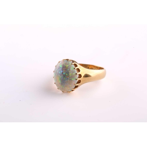 167 - A precious opal dress ring in 18ct yellow gold, composed of an oval precious opal cabochon, approxim... 