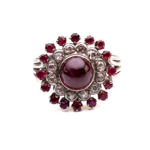 208 - A cabochon ruby and diamond cluster ring; the central, circular ruby in collet mount above a border ... 