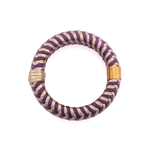 215 - Dior; a herringbone woven leather bangle in purple and gold with engraved gold-tone metal band engra... 