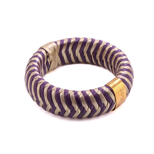 215 - Dior; a herringbone woven leather bangle in purple and gold with engraved gold-tone metal band engra... 