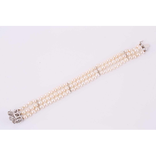 218 - A three-row pearl bracelet with gem-set clasp, comprising uniformed round cultured pearls of 5.0 mm ... 