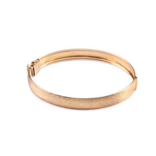 223 - A Florentine finish hinged bangle, fastens with a tongue and groove clasp, secures with a figure-of-... 