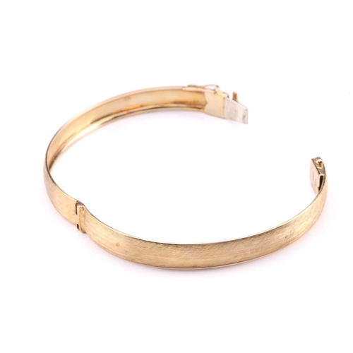 223 - A Florentine finish hinged bangle, fastens with a tongue and groove clasp, secures with a figure-of-... 