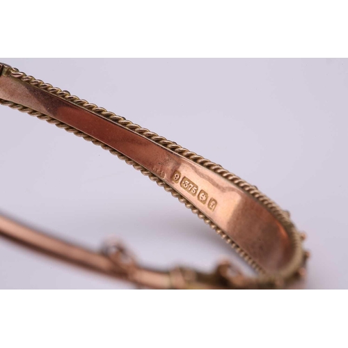 240 - An Edwardian 9ct gold hinged bangle and a 9ct gold chain; the bracelet contains a hollow band with a... 