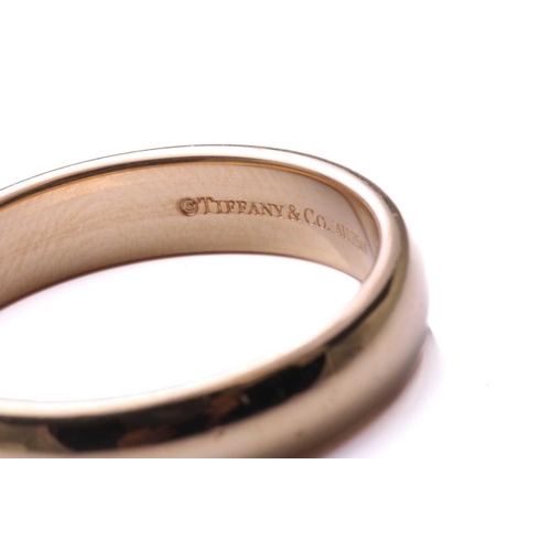 248 - Tiffany. An 18-carat yellow gold wedding band; of plain D section band, size Q, signed Tiffany &Co. ... 