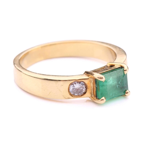 251 - An emerald and diamond dress ring in 18ct yellow gold, comprising an emerald-cut emerald in dark gre... 