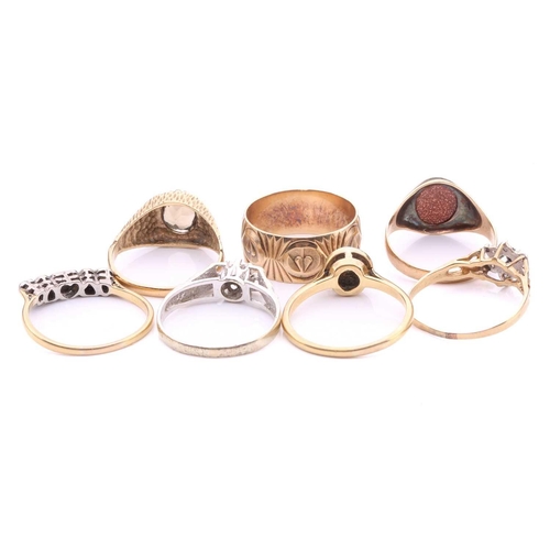 252 - A collection of seven rings, comprising a 9ct gold wedding band decorated with hearts on a textured ... 