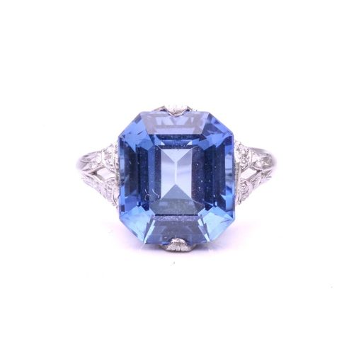 255 - A Belle Epoque sapphire and diamond ring; the octagonal, step-cut, cut-cornered sapphire in raised c... 