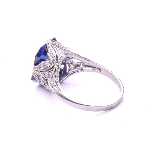 255 - A Belle Epoque sapphire and diamond ring; the octagonal, step-cut, cut-cornered sapphire in raised c... 