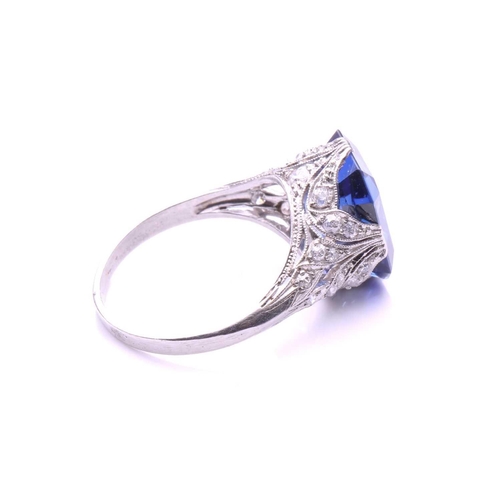 255 - A Belle Epoque sapphire and diamond ring; the octagonal, step-cut, cut-cornered sapphire in raised c... 