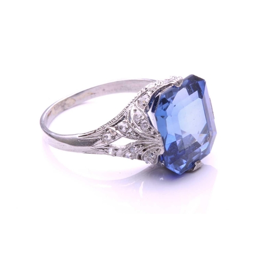 255 - A Belle Epoque sapphire and diamond ring; the octagonal, step-cut, cut-cornered sapphire in raised c... 