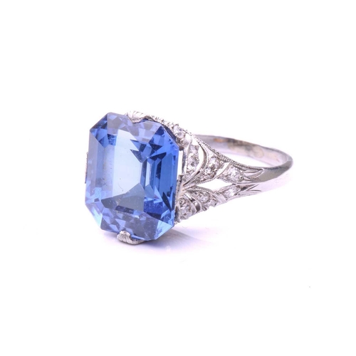 255 - A Belle Epoque sapphire and diamond ring; the octagonal, step-cut, cut-cornered sapphire in raised c... 