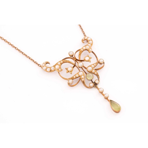 265 - An Edwardian peridot and seed pearl pendant necklace, the scrolled floral mount encrusted with seed ... 