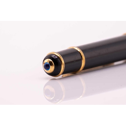 274 - A Cartier ballpoint pen, featuring black resin and gold plated parts with a twist design and set wit... 