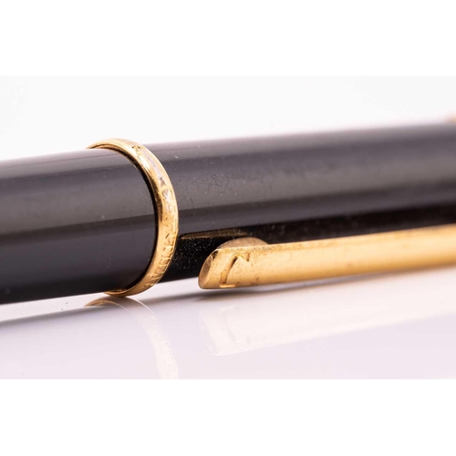 274 - A Cartier ballpoint pen, featuring black resin and gold plated parts with a twist design and set wit... 