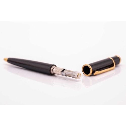 274 - A Cartier ballpoint pen, featuring black resin and gold plated parts with a twist design and set wit... 